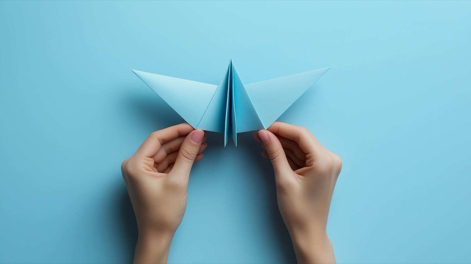 Hands folding a paper airplane